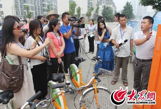 西線采訪團采訪了薛城區(qū)城市公共自行車服務系統(tǒng)，工作人員向記者們講解公共自行車的詳細情況。 記者 郭豪 攝。